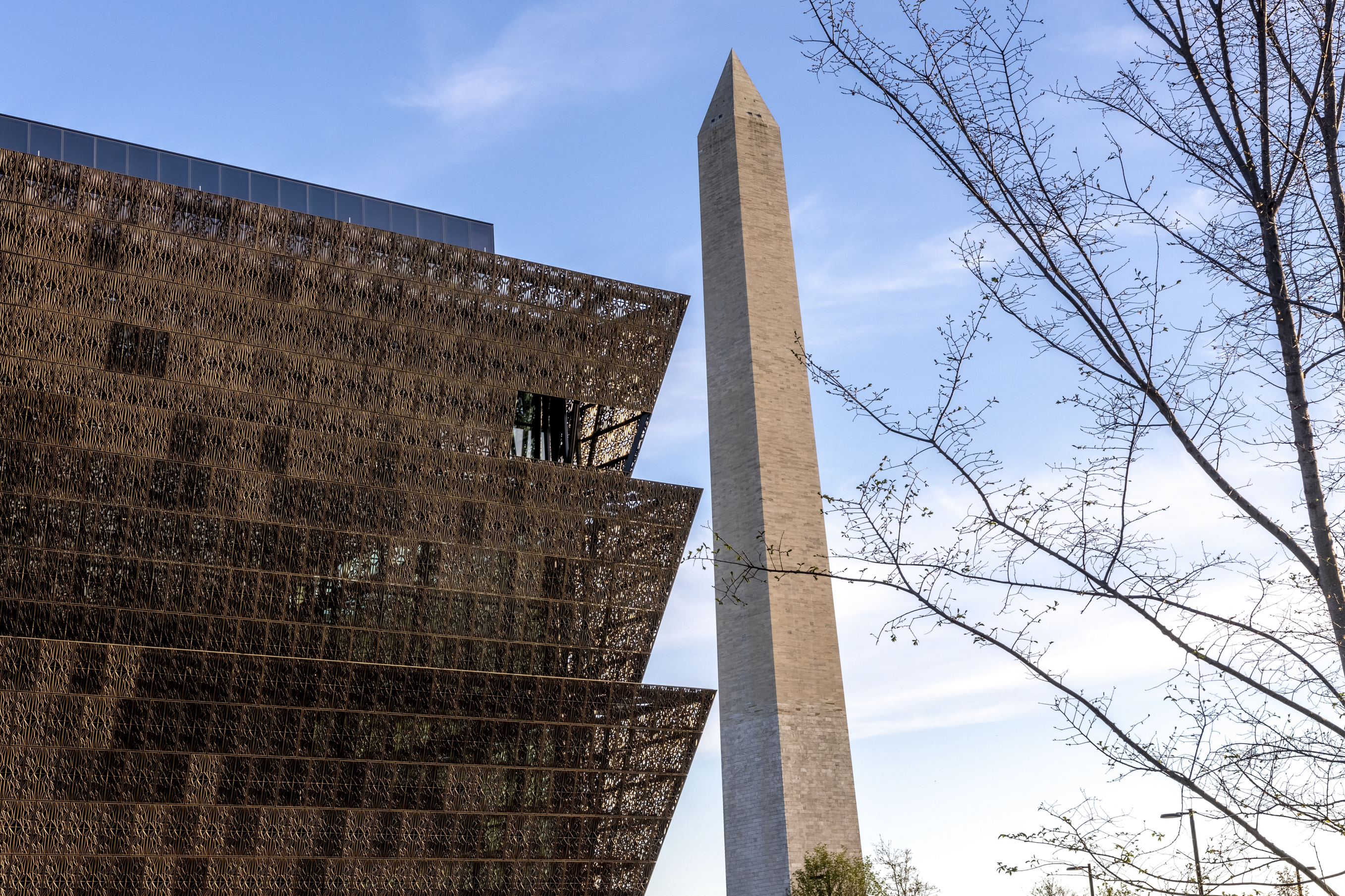 Photo of the National Museum of African American History and Culture with the Washington Monument in the background